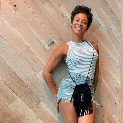 She is wearing a denim jeans and a fancy black handbag.